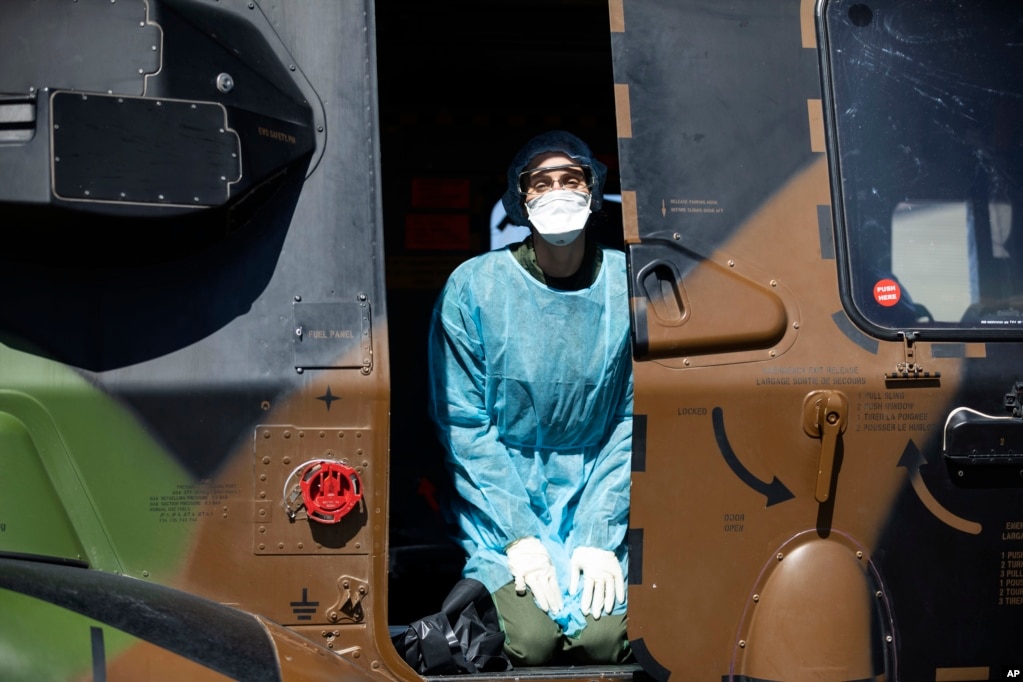 Un profesional médico se arrodilla en un helicóptero militar francés antes de evacuar a Suiza a un paciente infectado con el virus COVID-19, en Estrasburgo, al este de Francia.