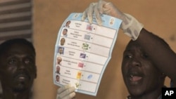 A Togolese electoral holds up a ballot papers in a polling station in Lome, 04 Mar 2010
