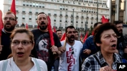 Supporters of the Greek Communist party chant slogans during an anti-war rally in front of the parliament, in Athens, Saturday, April 14, 2018. 