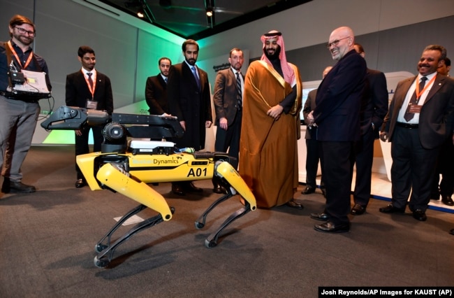 Saudi Crown Prince Mohammed bin Salman visits a demonstration of technology, including a robotic "SpotMini" dog presented by Boston Dynamics CEO Marc Raibert, during a visit to Massachusetts Institute of Technology on Saturday, March 24, 2018.