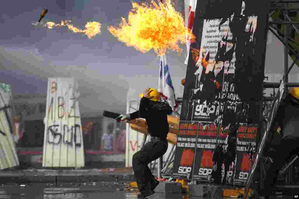 A protester throws a gas bomb towards riot police during clashes in Taksim Square in Istanbul, June 11, 2013.