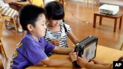 지난 6월 일본 도쿄 인근 요시카와 시 학교에서 아이들이 아이패드를 가지고 놀고 있다. (자료사진)