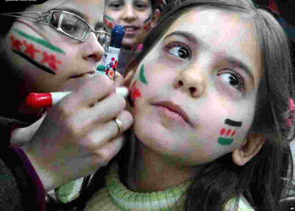 Girls paint their faces with colors of the Syrian revolutionary flag during a fesitval, in Aleppo, Syria, March 20, 2013.