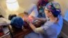 “Gi” sews healthcare scrub caps as part of her recovery from a panic attack and PTSD. She has moved from an emergency room nurse to a hospice unit. (Carolyn Presutti/VOA)