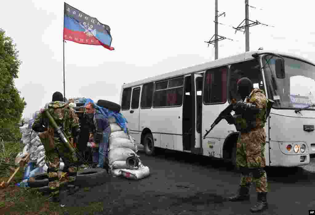 Pro-Russian masked and armed militants check the bus passengers&#39; luggage, Slovyansk, Wednesday, April 30, 2014.&nbsp;