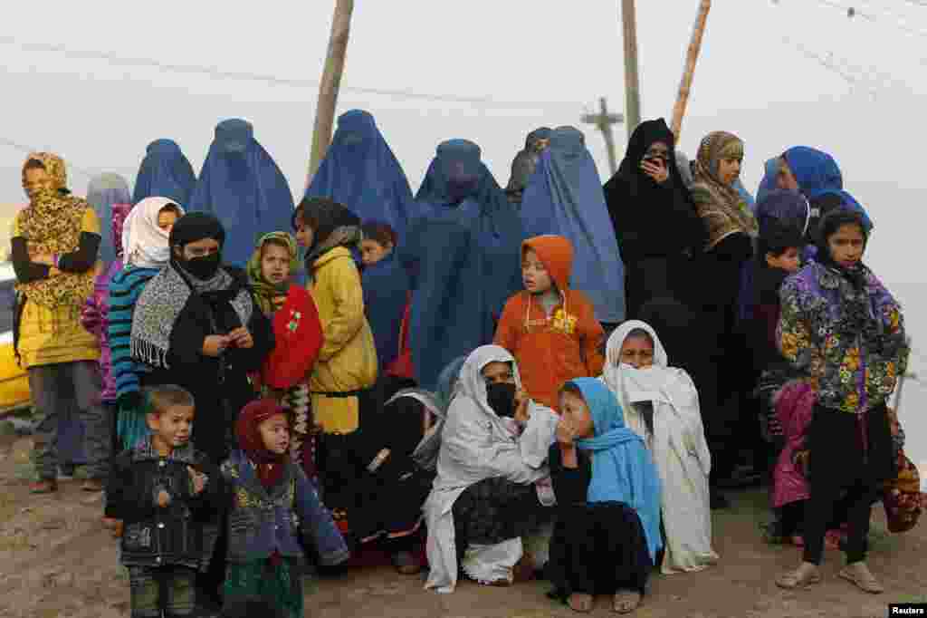 افغان عورتوں اور بچے کابل میں عاشورہ پر منعقد ایک جلوس کو دیکھ رہے ہیں۔