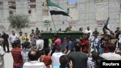 Anti-government protesters carry the body of Yaser Raqieh, whom protesters say was killed by forces loyal to Syria's President Bashar al-Assad, near Hama June 5, 2012. 
