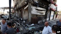 Civilians inspect damages the morning after a string of car bombs tore through busy shopping streets in several neighborhoods in Baghdad, Iraq, Aug. 7, 2014.