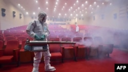 South Korean health officials fumigate a theater while wearing protective gear in Seoul, June 12, 2015.