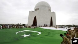 Students hold a giant representation of a Pakistani flag to celebrate the 68th Independence Day at the mausoleum of Muhammad Ali Jinnah, founder of Pakistan in Karachi, Pakistan, Thursday, Aug. 14, 2014.