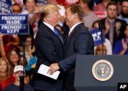 El presidente Donald Trump (izquierda) saluda al senador Dean Heller, republicano por Nevada, durante un acto de campaña el jueves, 20 de septiembre de 2018, en Las Vegas.