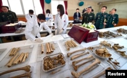 2015年3月16日韩国国防部遗骸发掘鉴识团阵亡局人员举行中国军人遗骸入殓仪式。在场的有中国驻韩国武官杜农一（右三）