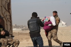 An Iraqi soldier carries a wounded girl into Mosul's only clinic for treatment before transport to a hospital, Nov. 27, 2016. (H. Murdock/VOA)