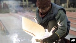 FILE - A welder from North Korea works in the Gdansk shipyard, in Gdansk, northern Poland, March 24, 2006. Poland has stopped issuing visas for North Korean workers.