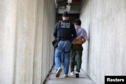 Một nhân viên của Cơ quan Chấp hành Di trú và Hải quan (ICE) bắt một người nhập cư Iran ở Santa Ana, California, ngày 11 tháng 5, 2017.