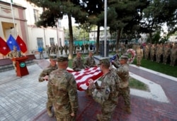 Tentara AS bersiap mengibarkan bendera Amerika dalam upacara peringatan serangan 9/11, di Kabul, Afghanistan. (Foto: REUTERS/Mohammad Ismail)