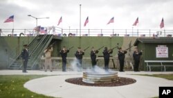 Members of American Legion Post 9, and VFW Post 9388 fire a 21-gun salute during a flag retirement ceremony, Sunday, Nov. 10, 2013, in front of the USS LST 393 Veterans Museum in Muskegon, Michigan.