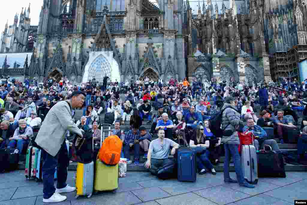 Passengers wait outside the main train station in Cologne, Germany, as the train station was closed due to a suspected hostage-taking.