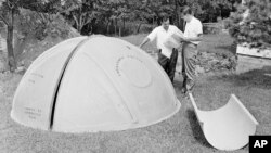FILE - Bomb shelter manufacturer engineers Vincent Carubia, left, and Eward Klein study specifications for a fiber glass dome shelter being installed on an estate in Locust Valley, N.Y., Sept. 7, 1961.