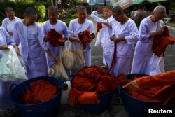 Thai women devotees wearing white robes return saffron robes after ending their novice monkhood at the Songdhammakalyani monastery, Nakhon Pathom province, Thailand, Dec. 14, 2018. Officially, only men can become monks and novices in Thailand.