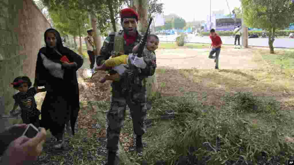 نیروهای امنیتی در حال انتقال کودکان و کمک به مردم پس از حمله بر مراسم رسم گذشت بر سپاه پاسداران در شهر اهواز&nbsp; &nbsp;