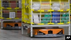 In this Dec. 5, 2018, photo, pods full of merchandise are moved around the floor by robotic drives, named Amazon robots, at the Amazon fulfillment center on Staten Island borough of New York. (AP Photo/Mary Altaffer)