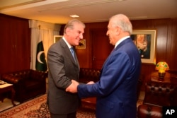 In this photo released by the Foreign Office, Pakistan's Foreign Minister Shah Mahmood Qureshi, left, receives U.S. envoy Zalmay Khalilzad at the Foreign Ministry in Islamabad, Pakistan, Jan. 18, 2019.