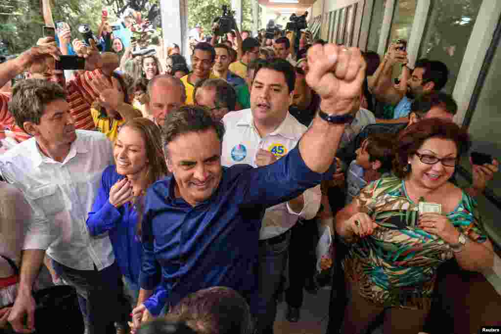 Kandidat presiden Aecio Neves dan istrinya Leticia Weber tiba untuk memberikan suara dalam pemilihan umum di&nbsp;Belo Horizonte (5/10).&nbsp;(Reuters/Pedro Vilela) 