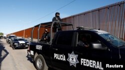 Мексиканська федеральна поліція охороняє стіну під час візиту президента США Дональда Трампа до Калексико, Каліфорнія, в Мехікалі, Мексика, 5 квітня 2019 року.