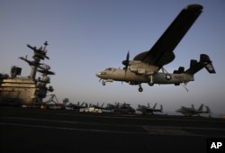 FILE - An aircraft lands after missions targeting the Islamic State group in Iraq from the deck of the U.S. Navy aircraft carrier USS George H.W. Bush in the Persian Gulf.