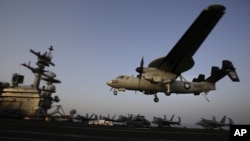 FILE - In this Aug. 10, 2014, file photo, an aircraft lands after missions targeting the Islamic State group in Iraq from the deck of the U.S. Navy aircraft carrier USS George H.W. Bush in the Persian Gulf. 