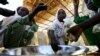 FILE - Internally displaced schoolchildren eat from the same bowl during a feeding program provided by the World Food Program at the Abushouk camp in Al-Fasher in North Darfur, Sudan, Nov. 17, 2015.