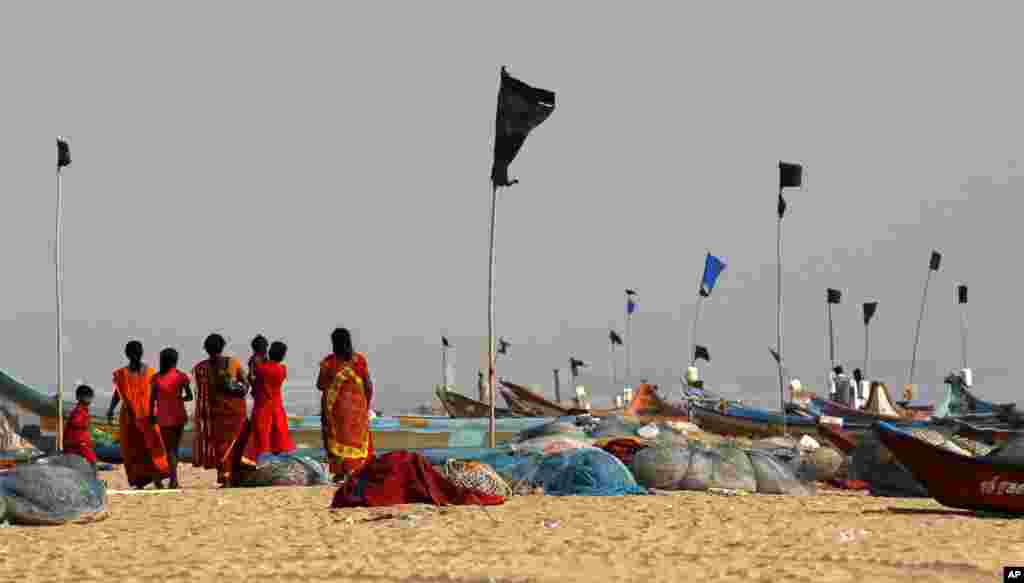 Des spectateurs, debout sur la plage Marina, contemplent les vagues de la baie du Bengale lors d&#39;une cérémonie pour commémorer le 10ème anniversaire du tsunami de 2004 à Chennai, en Inde, vendredi 26 décembre 2014.