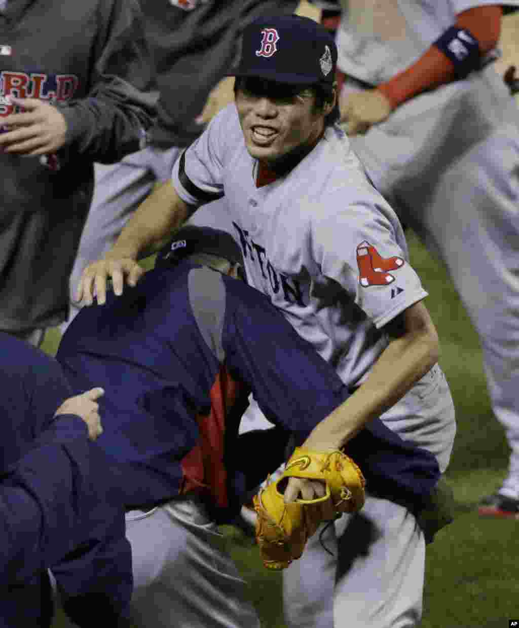 Boston Red Sox relief pitcher Koji Uehara, right, celebrates after picking off St. Louis Cardinals Kolten Wong at first base to end Game 4 of baseball's World Series, Oct. 27, 2013, in St. Louis.