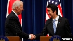 U.S. Vice President Joe Biden (L) shakes hands with Japan's Prime Minister Shinzo Abe at the end of their joint news conference following their meeting at the prime minister's official residence in Tokyo, Dec. 3, 2013. Biden urged Japan and China to lower
