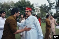 FILE - Peshawar provincial assembly candidate Haroon Bilour, center, greets party activists before a meeting for the forthcoming general election in Peshawar, April 25, 2013.