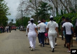 Nurses walk to the site where a Cuban airliner with more than 100 passengers on board plummeted into a field just after takeoff from the international airport in Havana, Cuba, May 18, 2018.