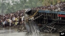 Warga desa Buraburi menarik bangkai perahu yang terbelah dari sungai Brahmaputra (1/5). Regu penyelamat dan penyelam telah menemukan sedikitnya 100 korban musibah tersebut, dan selebihnya masih dinyatakan hilang.