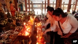 Local residents light candles during a ceremony to celebrate Pchum Ben, or Ancestors' Day at Krang Thnung Buddhist pagoda on the outskirts of Phnom Penh, Cambodia, Monday, Sept. 28, 2015. The traditional 15-day festival, which commemorates the spirits of the dead, began on Monday. (AP Photo/Heng Sinith)