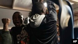 Migrants celebrate on the deck of the Rise Above rescue ship run by the German organization Mission Lifeline, in the Mediterranean Sea off the coasts of Sicily, southern Italy, Monday, Nov. 7, 2022.