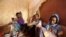 FILE - Illegal immigrants from Ethiopia attempting to cross into Yemen smoke shisha in their makeshift shelter in Bosasso, northern Somalia's breakaway Puntland region, Apr. 14, 2015. 