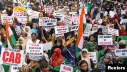 Women display placards during a protest, organized by West Bengal State Jamiat-e-Ulama, an Islamic organization, against a new citizenship law, in Kolkata, India, Dec. 22, 2019.