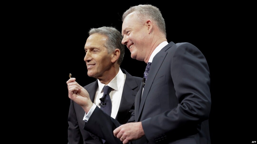 Kepala sekaligus CEO Starbucks, Howard Shultz (kiri), menyerahkan kunci toko Starbucks pertama di Pike Place Market di Seattle, kepada Chief Operating Officer Kevin Johnson dalam acara rapat pemegang saham tahunan di McCaw Hall di Seattle, Washington, 22 Maret 2017. (foto:dok)