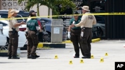 Law enforcement officials work the scene of a shooting outside a banquet hall near Hialeah, Fla., May 30, 2021. 