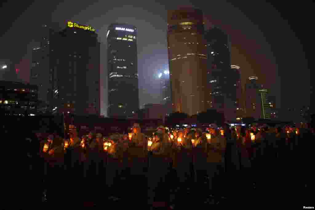 People hold candles during an event attempting to establish a Guinness world record for &#39;blowing out the most number of candles simultaneously&#39; during Earth Hour in Shanghai.
