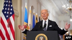 US President Joe Biden gestures as he speaks on the anniversary of the start of the Covid-19 pandemic, in the East Room of the White House in Washington, DC on March 11, 2021. 