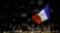 FILE - A supporter raises a French flag at a campaign rally in Nimes, France, Nov. 18, 2016.