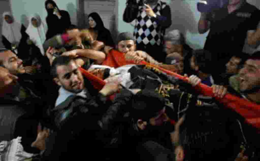 Palestinian mourners carry the body of Saber Assalya, an Islamic Jihad militant, during his funeral in Jabalya refugee camp, northern Gaza Strip, March 27, 2011