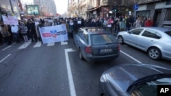 People stop traffic and stand in silence in front of the state-run TV headquarters in Belgrade, Serbia, on Dec. 27, 2024. They are part of ongoing protests that erupted after a concrete canopy fell last month and killed 15 people.