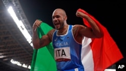 Lamont Jacobs of Italy celebrates after taking the gold medal in the final of the men's 4 x 100-meter relay at the 2020 Summer Olympics, Friday, Aug. 6, 2021, in Tokyo, Japan. (AP Photo/Charlie Riedel)